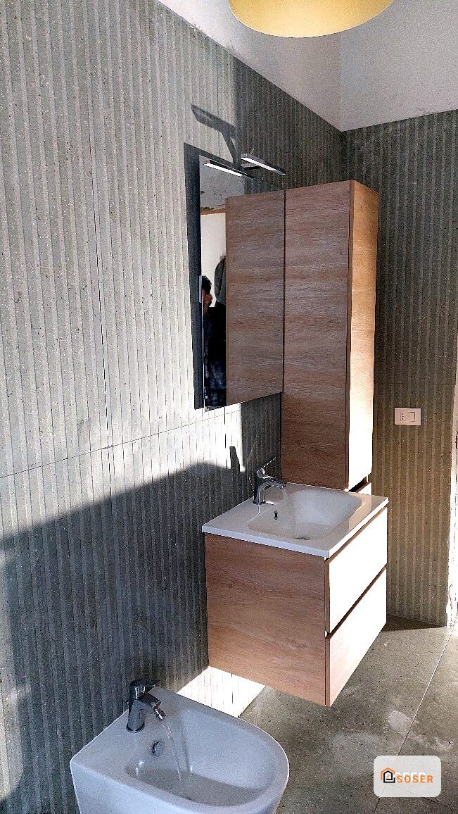 Bagno moderno con mobile lavabo in legno, specchio contenitore e rivestimenti in gres