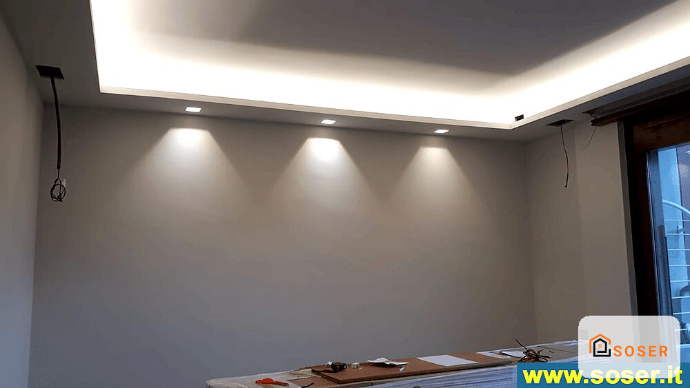 Controsoffitto in cartongesso con illuminazione LED integrata e faretti incassati in una stanza moderna