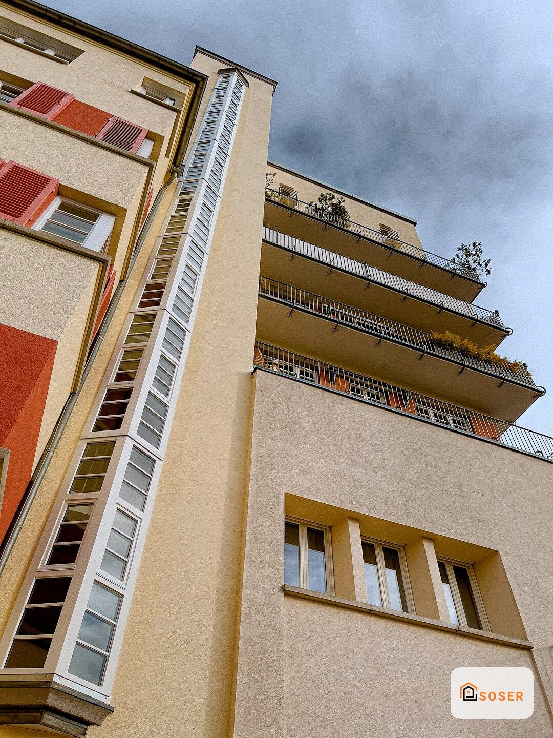 Facciata di edificio residenziale a Milano con balconi in ferro e infissi colorati