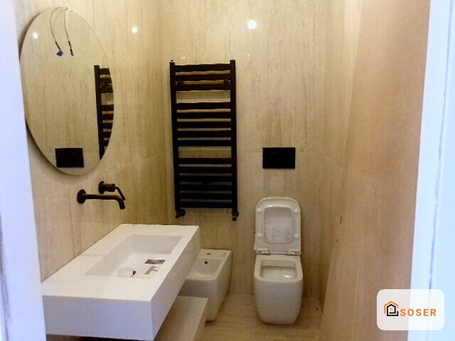 Bagno moderno completamente ristrutturato con lavabo bianco, wc sospeso e scaldasalviette nero a parete