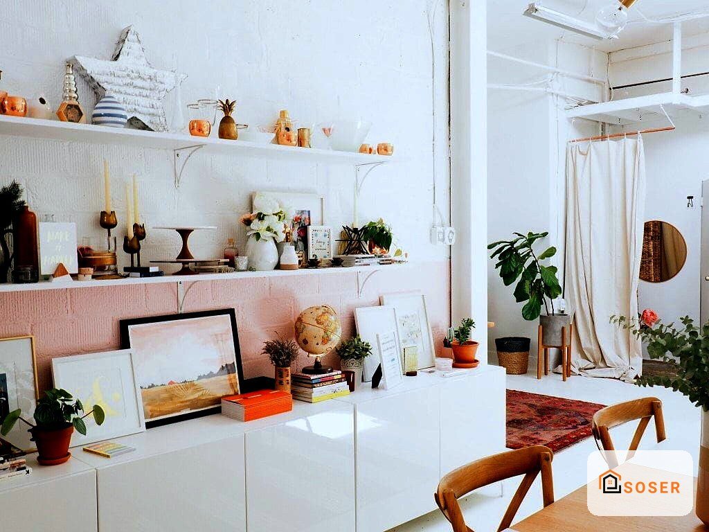 Ufficio moderno con pareti bianche, scaffali rosa e scrivania bianca, arredamento minimalista e piante decorative