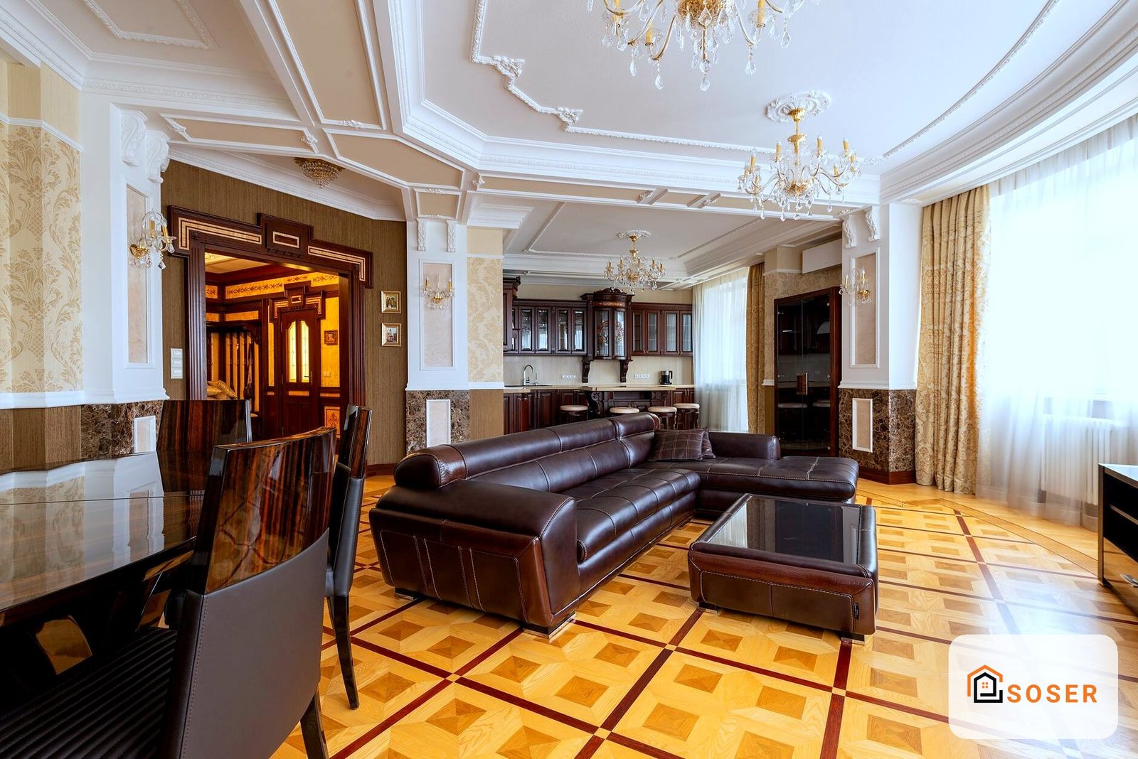Lussuoso soggiorno con divano in pelle marrone, pavimenti in legno geometrico e soffitti decorati con stucchi