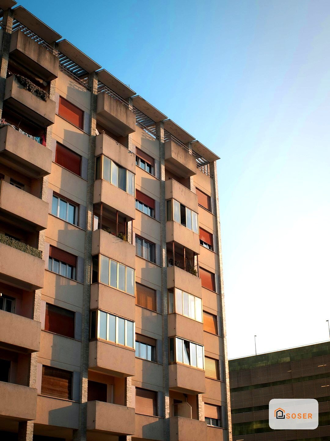 Facciata di edificio residenziale con rivestimento in laterizio e balconi in cemento armato