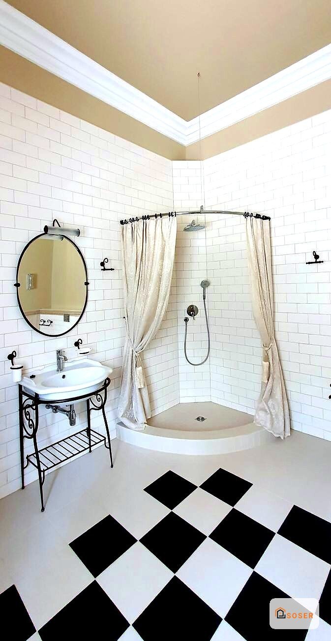 Bagno moderno con piastrelle bianche, pavimento a scacchiera nero e bianco, specchio ovale e doccia con tenda