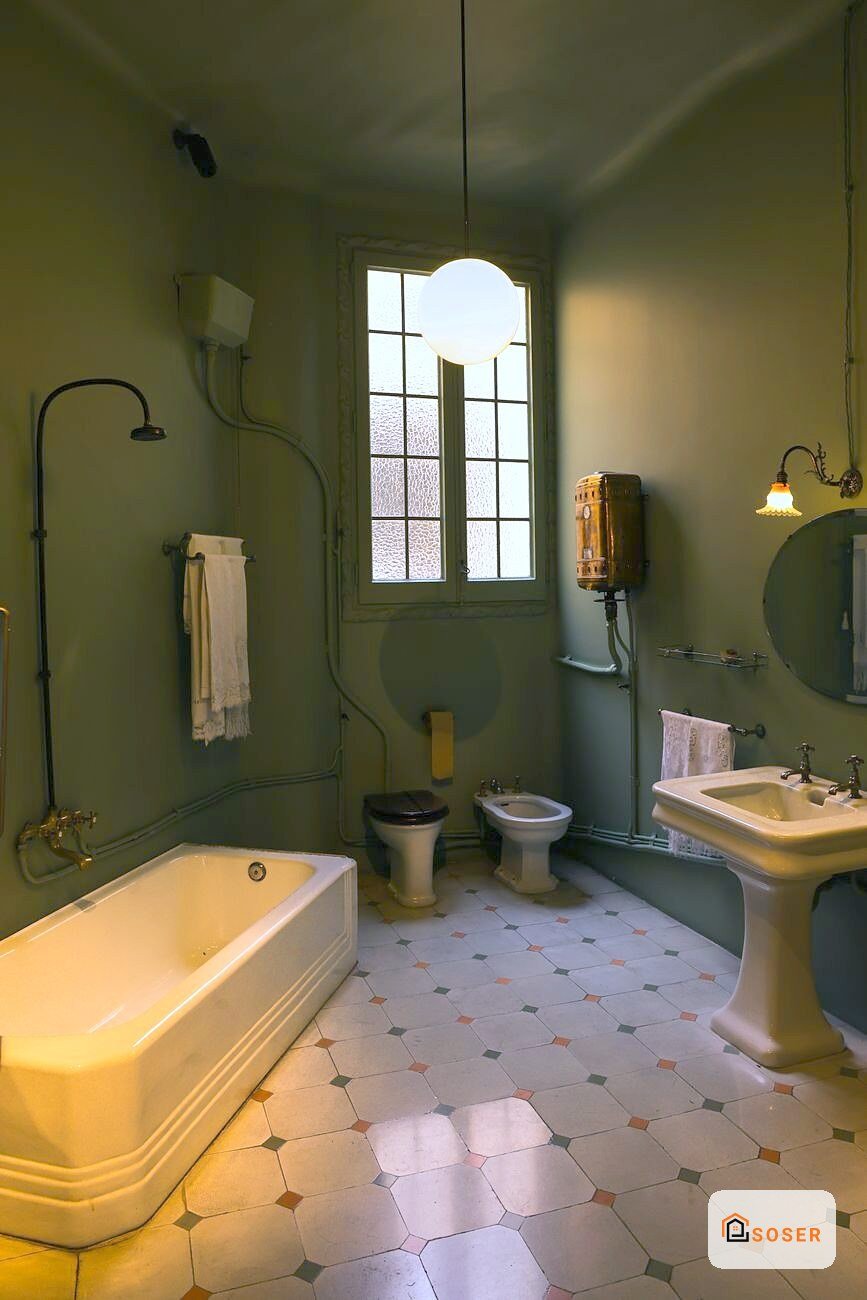 Bagno vintage con pareti verdi, vasca gialla, due water e lavandino, pavimento a quadretti colorati e finestra con vetrata