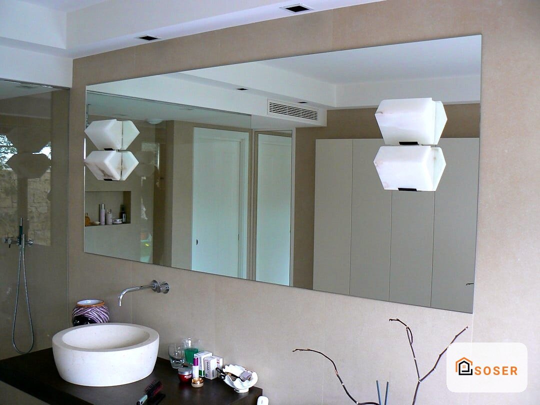 Bagno moderno con lavabo rotondo bianco, grande specchio illuminato e finiture in tonalità neutre