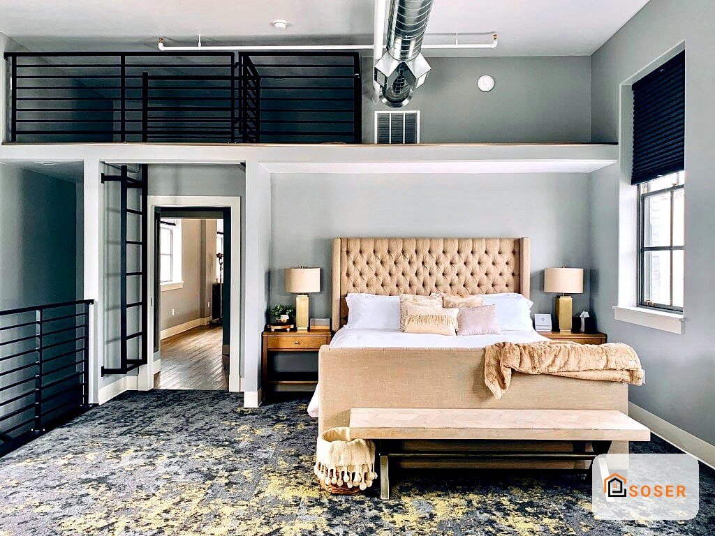 Camera da letto moderna con testata imbottita beige, pareti grigio salvia e mezzanino con ringhiera nera