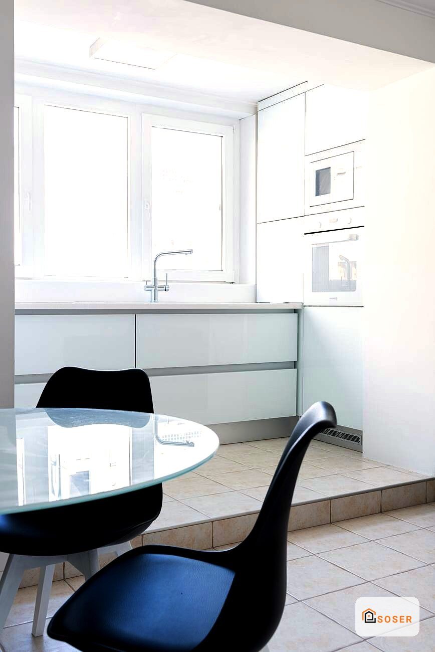 Cucina moderna con isola, infissi bianchi e mobili grigio-azzurri, progetto di ristrutturazione a Milano
