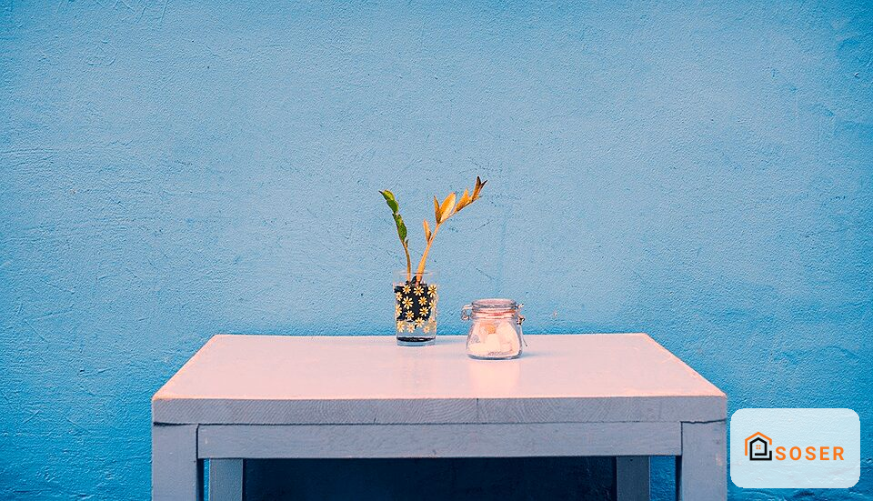 Parete blu brillante con tavolo bianco e vaso decorativo, esempio di imbiancatura moderna