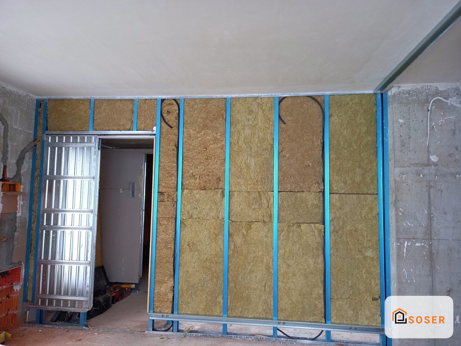 Parete in costruzione con isolamento termico in lana di roccia e profili metallici blu