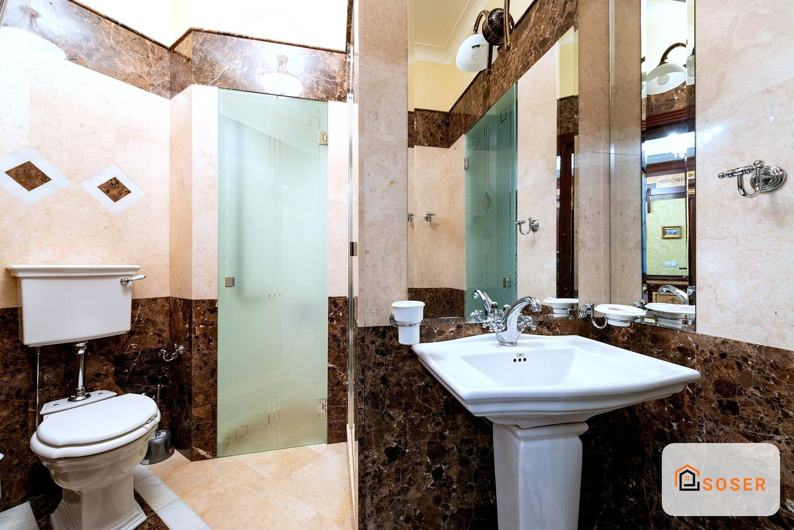 Bagno moderno con rivestimento in marmo marrone e bianco, lavabo sospeso e doccia in vetro