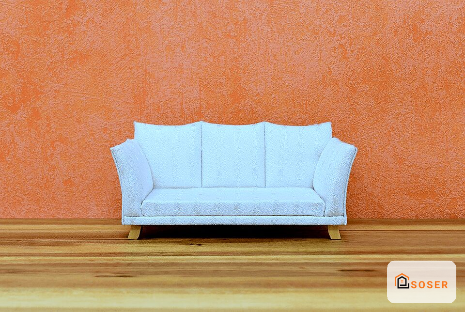 Divano azzurro moderno contro parete arancione in interior design minimalista