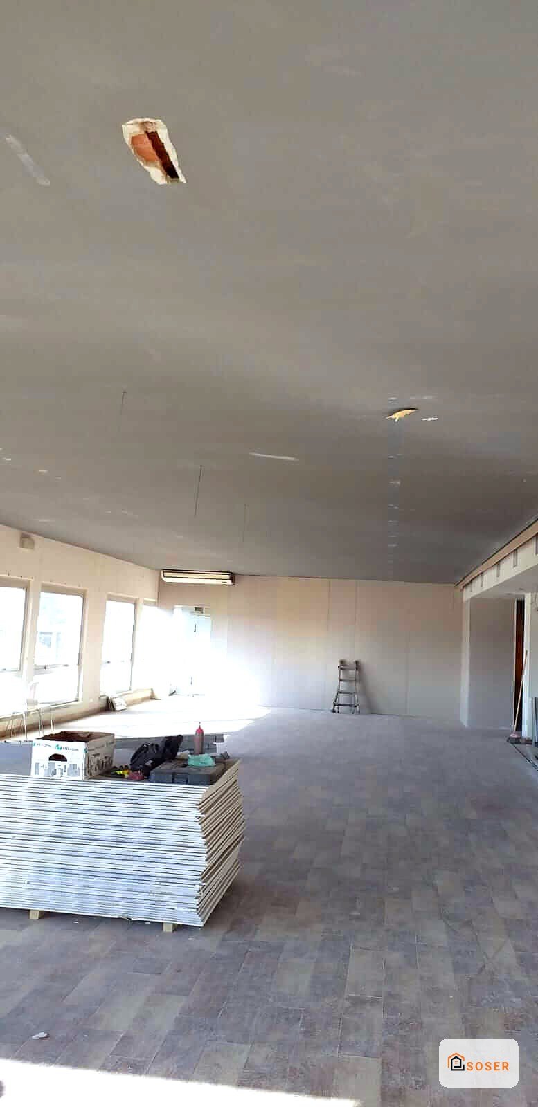 Interno di appartamento in fase di ristrutturazione con controsoffitto in cartongesso e pavimento in posa