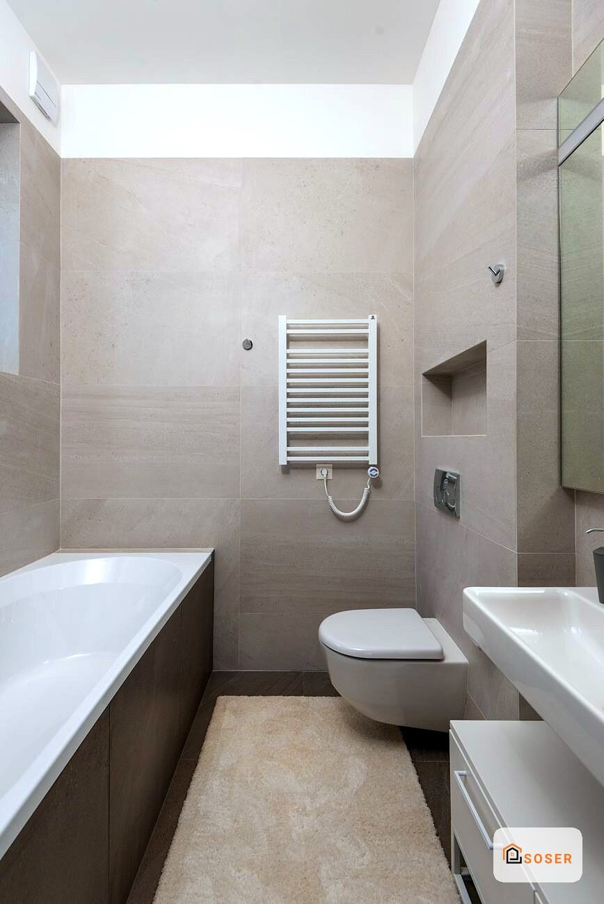 Bagno moderno ristrutturato con piastrelle beige, sanitari bianchi e skylight