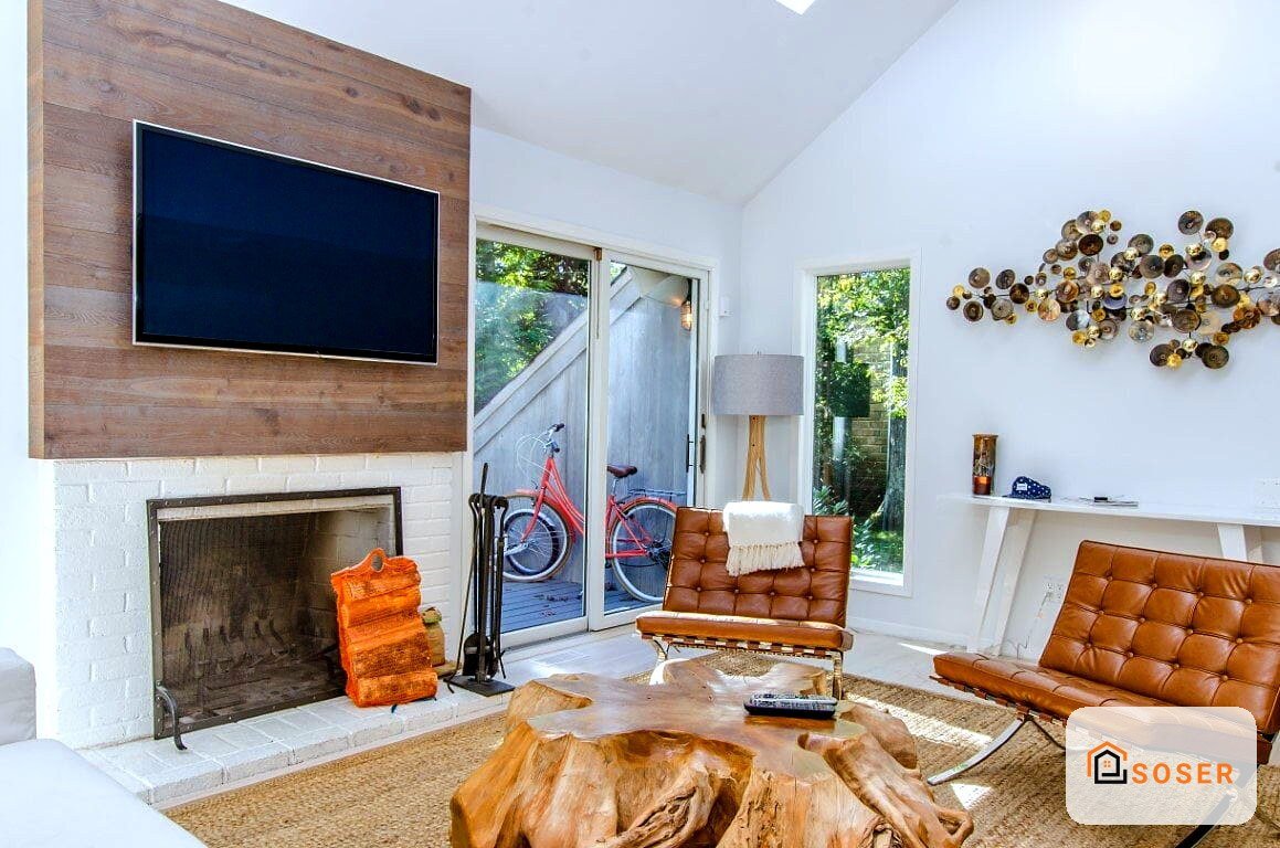 Salotto moderno con camino rivestito in cartongesso bianco, TV su pannello in legno e infissi in alluminio