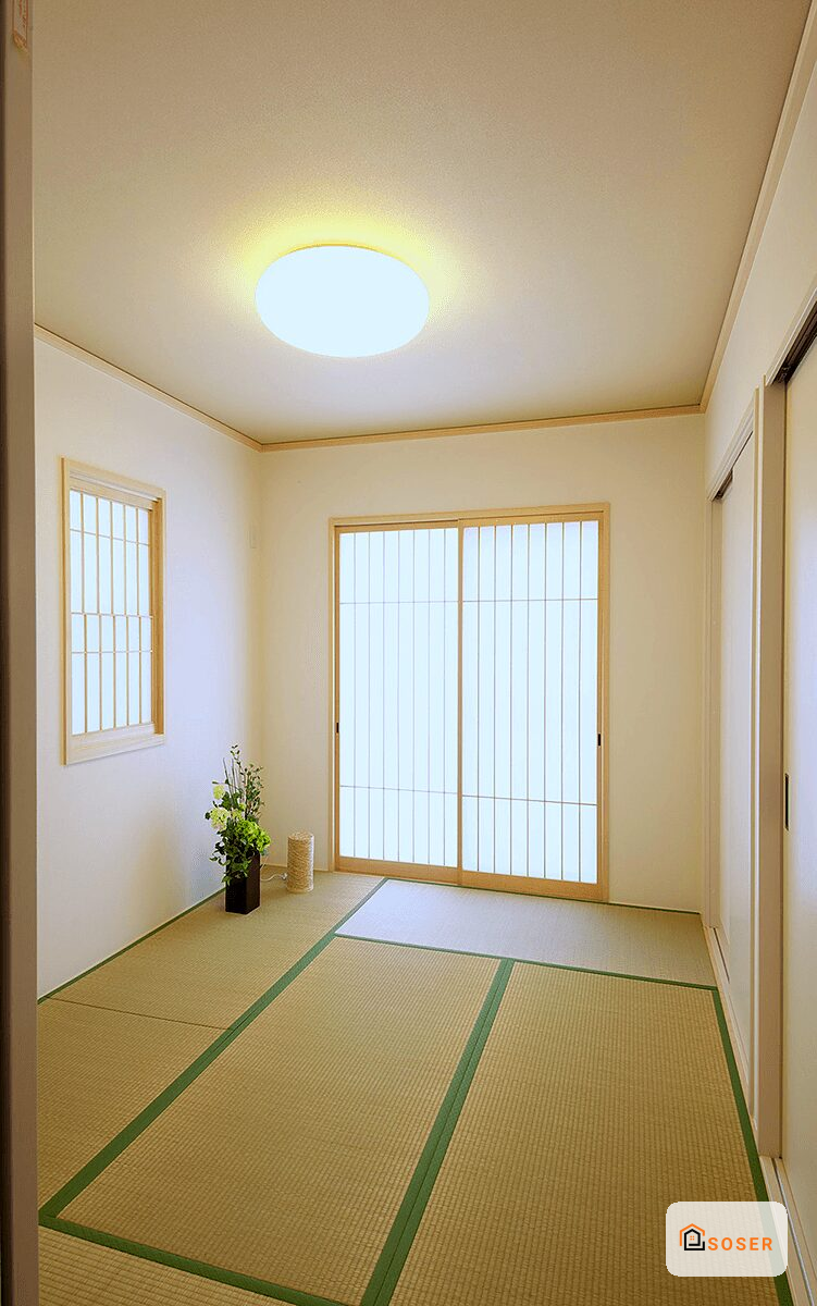 Stanza in stile giapponese con pavimento tatami, infissi in legno naturale e lampada a soffitto moderna