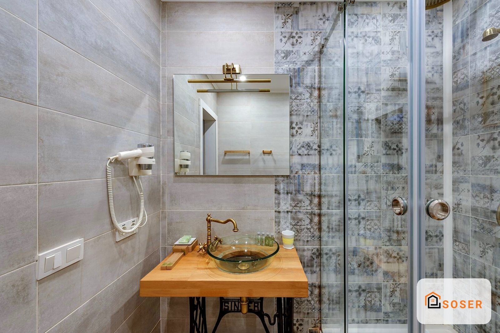 Bagno moderno con lavabo in vetro, specchio con cornice in legno e doccia con piastrelle decorative