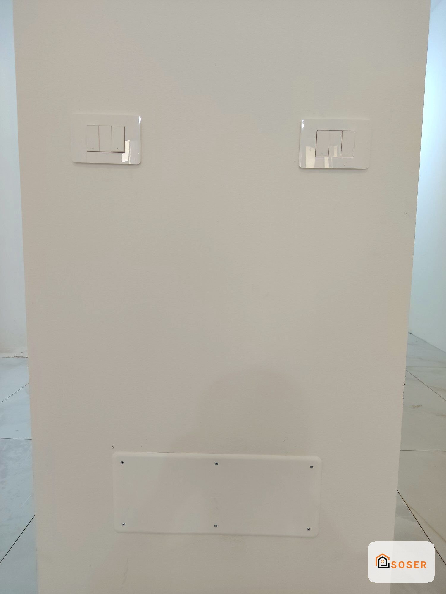 Parete in cartongesso con interruttori elettrici e placche bianche in fase di installazione